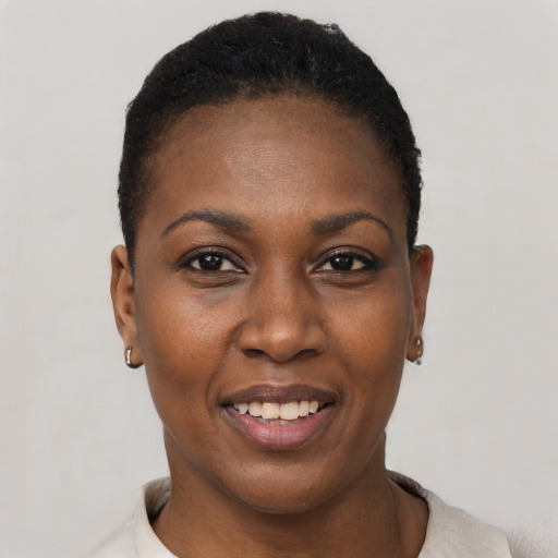 Joyful black young-adult female with short  black hair and brown eyes