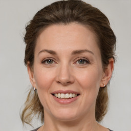 Joyful white adult female with medium  brown hair and grey eyes