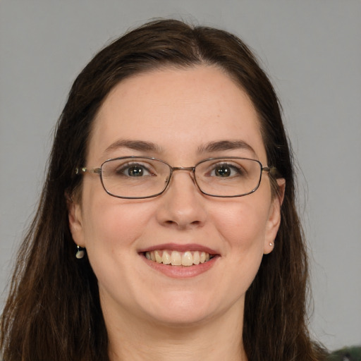 Joyful white adult female with long  brown hair and green eyes