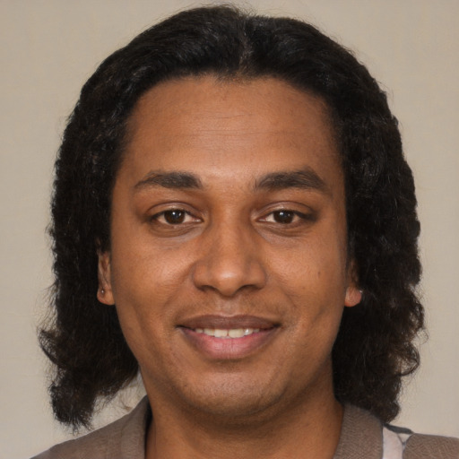 Joyful black adult male with medium  brown hair and brown eyes