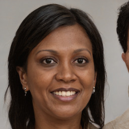 Joyful black adult female with long  brown hair and brown eyes