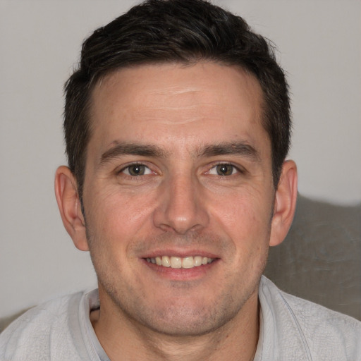 Joyful white adult male with short  brown hair and brown eyes