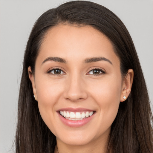 Joyful white young-adult female with long  brown hair and brown eyes