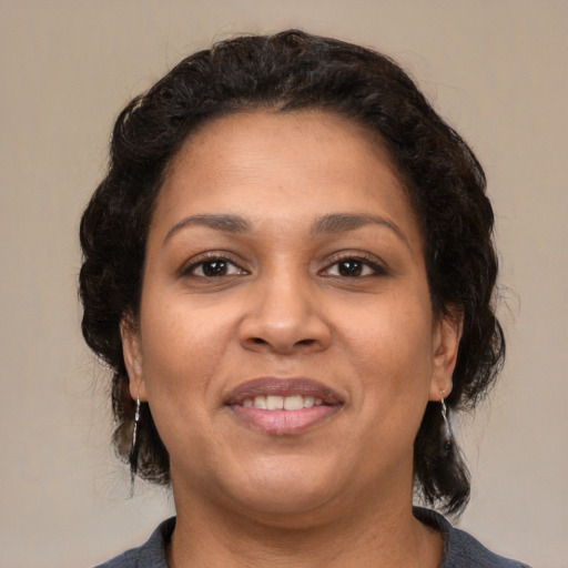 Joyful latino adult female with medium  brown hair and brown eyes