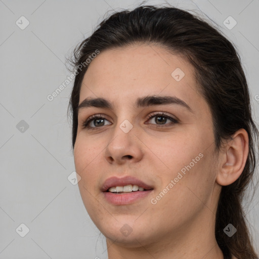 Joyful white young-adult female with long  brown hair and brown eyes