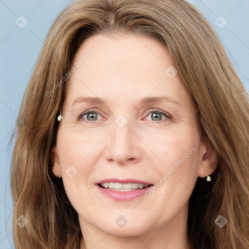 Joyful white adult female with long  brown hair and green eyes