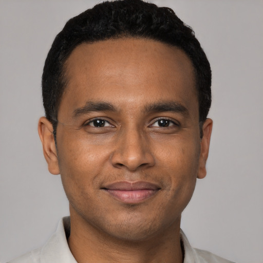 Joyful black young-adult male with short  black hair and brown eyes