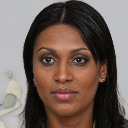 Joyful black young-adult female with long  brown hair and brown eyes