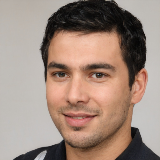 Joyful white young-adult male with short  black hair and brown eyes