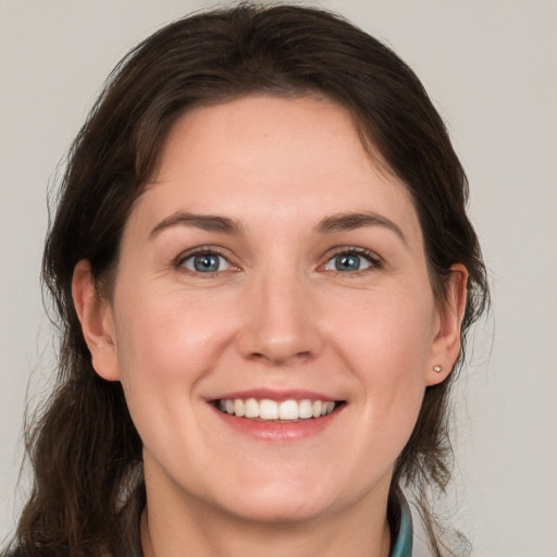 Joyful white young-adult female with medium  brown hair and grey eyes