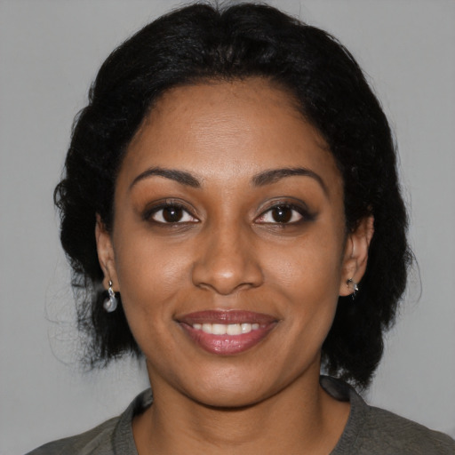 Joyful black young-adult female with medium  black hair and brown eyes