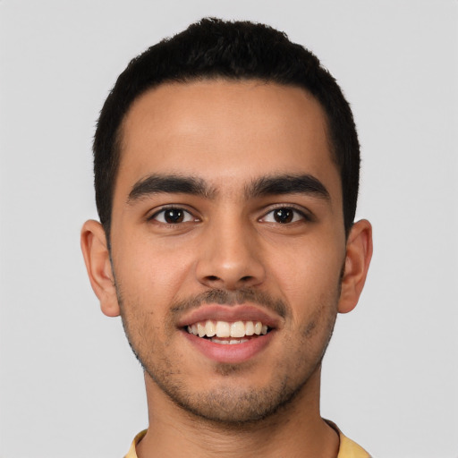 Joyful latino young-adult male with short  black hair and brown eyes