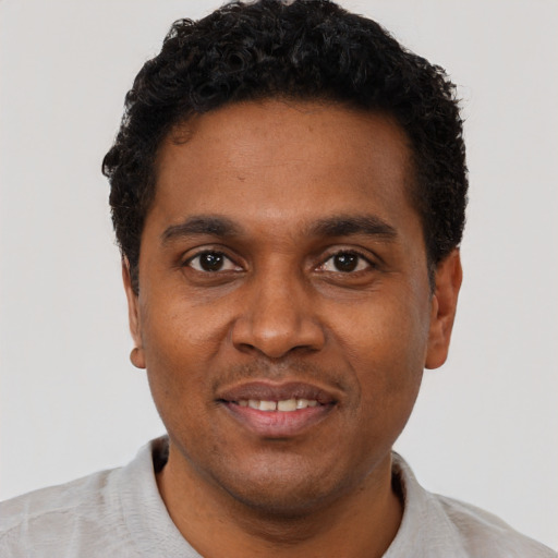 Joyful black young-adult male with short  black hair and brown eyes