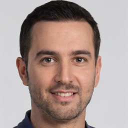Joyful white young-adult male with short  black hair and brown eyes
