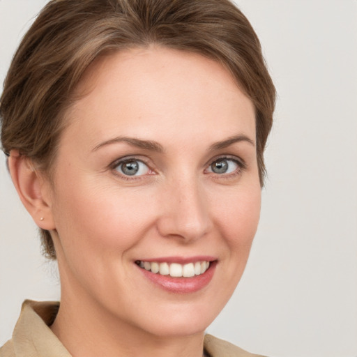 Joyful white young-adult female with short  brown hair and grey eyes