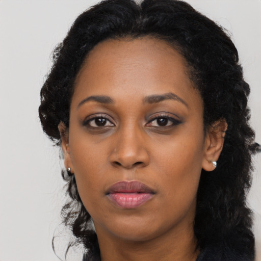 Joyful black young-adult female with long  black hair and brown eyes