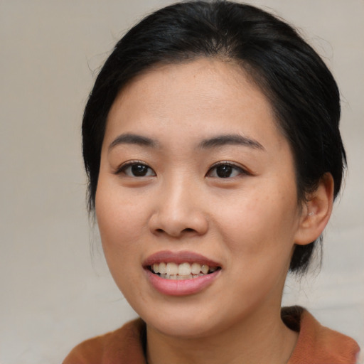 Joyful asian young-adult female with medium  black hair and brown eyes