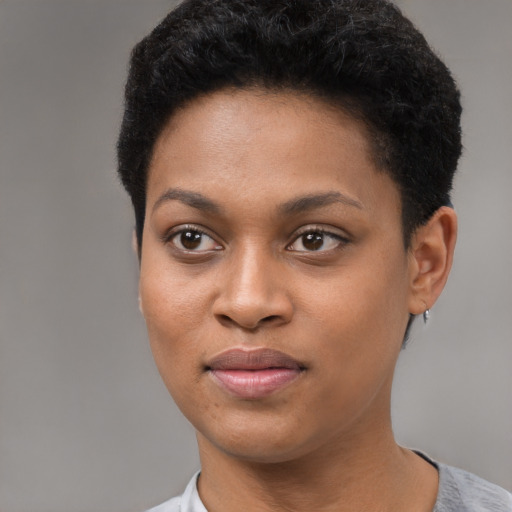 Joyful black young-adult female with short  black hair and brown eyes