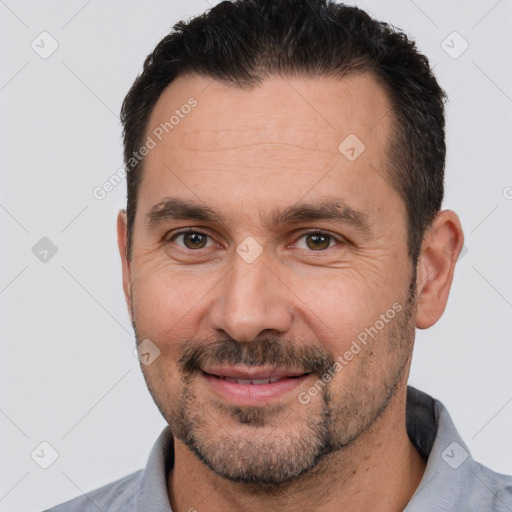 Joyful white adult male with short  black hair and brown eyes