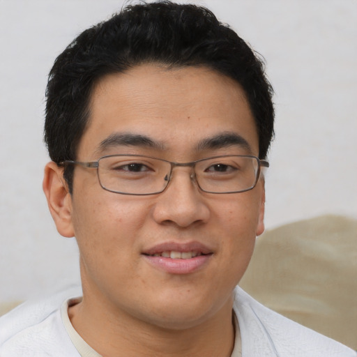 Joyful asian young-adult male with short  brown hair and brown eyes