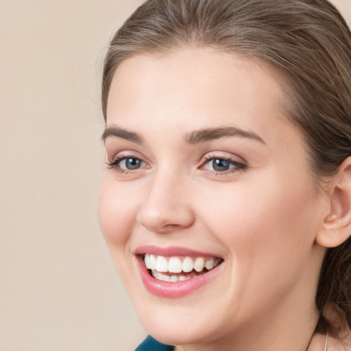 Joyful white young-adult female with medium  brown hair and grey eyes