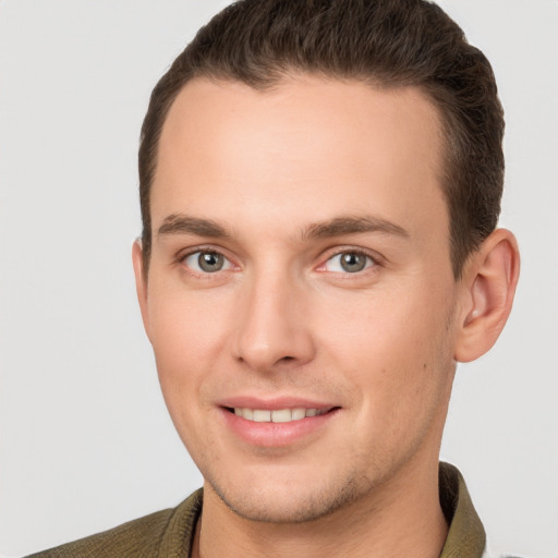 Joyful white young-adult male with short  brown hair and grey eyes