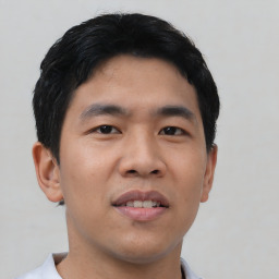 Joyful asian young-adult male with short  black hair and brown eyes