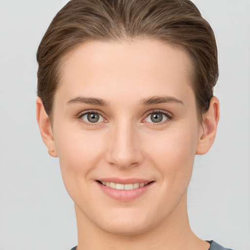 Joyful white young-adult female with short  brown hair and grey eyes