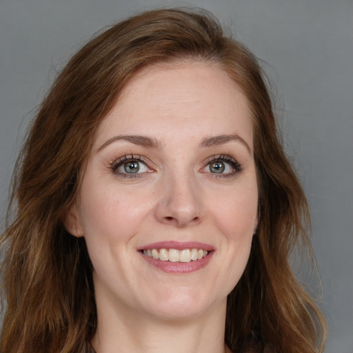 Joyful white young-adult female with long  brown hair and blue eyes