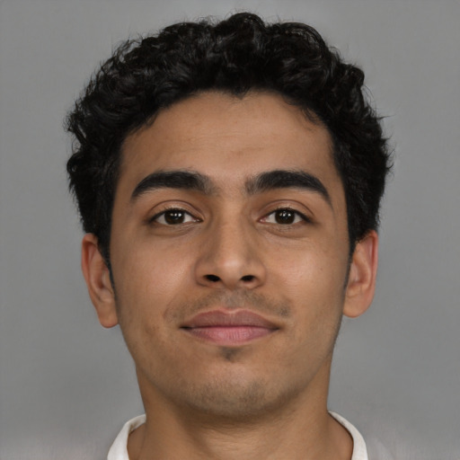 Joyful latino young-adult male with short  brown hair and brown eyes