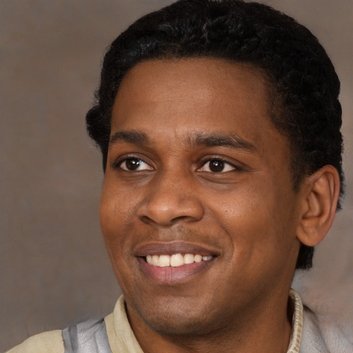 Joyful black young-adult male with short  black hair and brown eyes