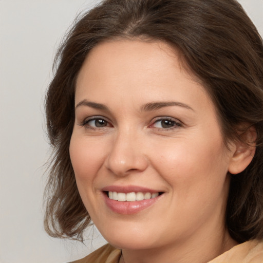 Joyful white adult female with medium  brown hair and brown eyes