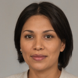 Joyful latino adult female with medium  brown hair and brown eyes