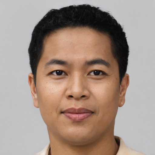 Joyful latino young-adult male with short  black hair and brown eyes