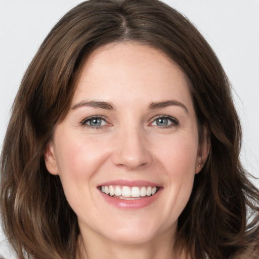 Joyful white young-adult female with long  brown hair and grey eyes