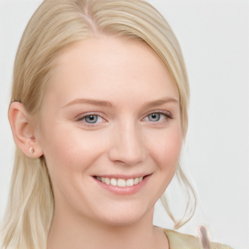 Joyful white young-adult female with long  blond hair and blue eyes