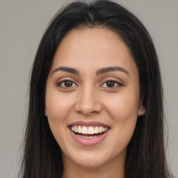 Joyful latino young-adult female with long  brown hair and brown eyes