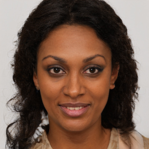 Joyful black young-adult female with long  brown hair and brown eyes