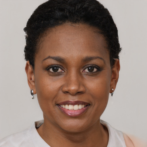 Joyful black young-adult female with short  black hair and brown eyes