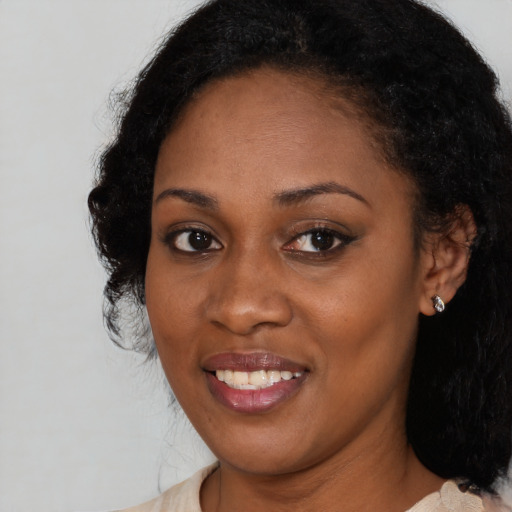 Joyful black young-adult female with medium  black hair and brown eyes