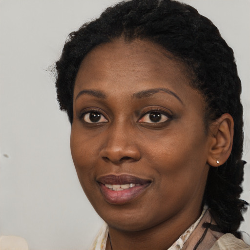 Joyful black young-adult female with long  brown hair and brown eyes