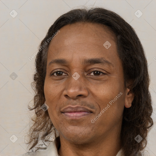 Joyful black adult female with long  brown hair and brown eyes