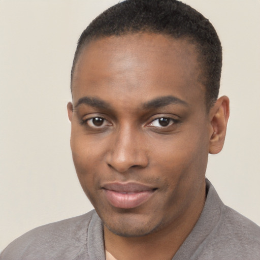 Joyful black young-adult male with short  brown hair and brown eyes