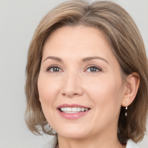 Joyful white adult female with medium  brown hair and brown eyes