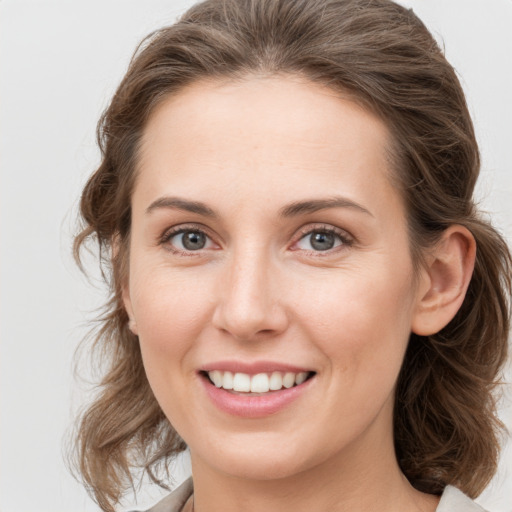 Joyful white young-adult female with medium  brown hair and grey eyes