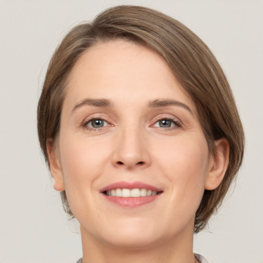 Joyful white young-adult female with medium  brown hair and grey eyes