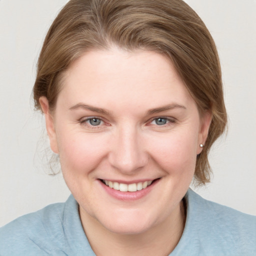 Joyful white young-adult female with medium  brown hair and blue eyes