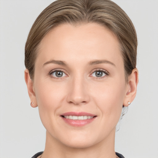 Joyful white young-adult female with medium  brown hair and grey eyes