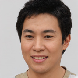 Joyful asian young-adult male with short  brown hair and brown eyes