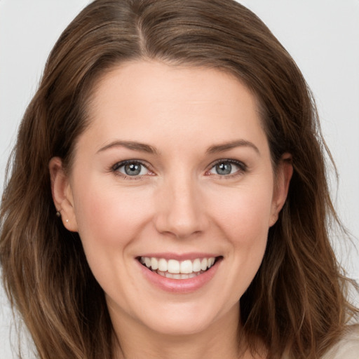 Joyful white young-adult female with long  brown hair and grey eyes